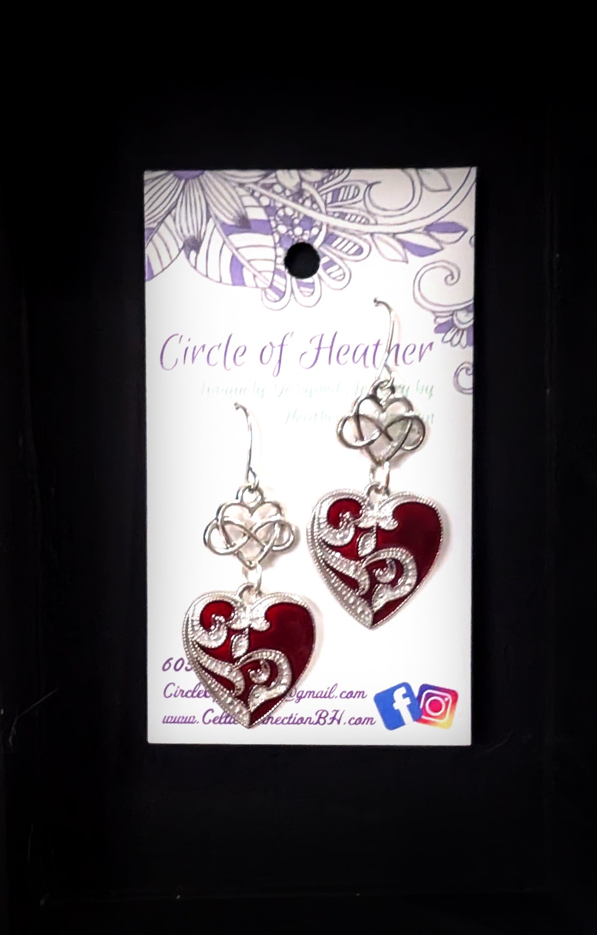 Infinity Hearts Earrings by Circle of Heather on the original branded card, silver-tone dangle earrings with an infinity heart knot above a filigree heart in deep red enamel