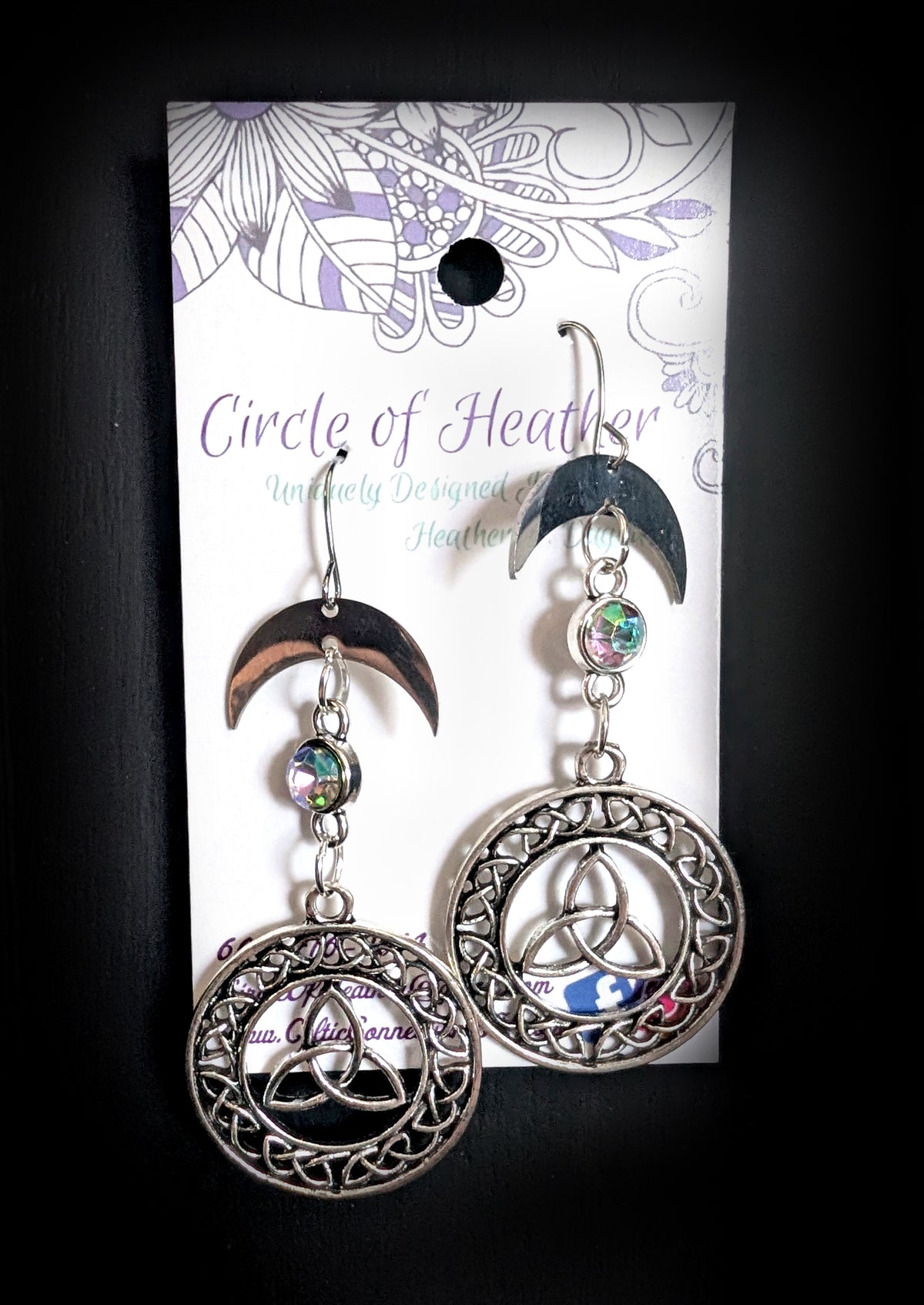 Knotted Luna Trinity Earrings by Circle of Heather, both earrings shown on the branded Circle of Heather card with crescent moons, iridescent stones and Celtic knotwork trinity medallions.
