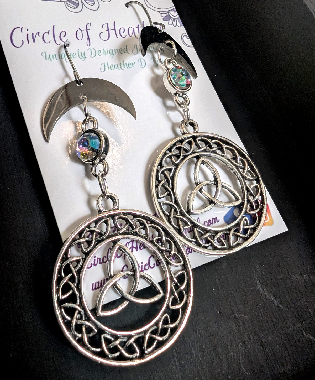 Knotted Luna Trinity Earrings by Circle of Heather, angled close-up showing the braided knotwork border and the trinity knot at the center of each medallion, shown on the branded Circle of Heather card.