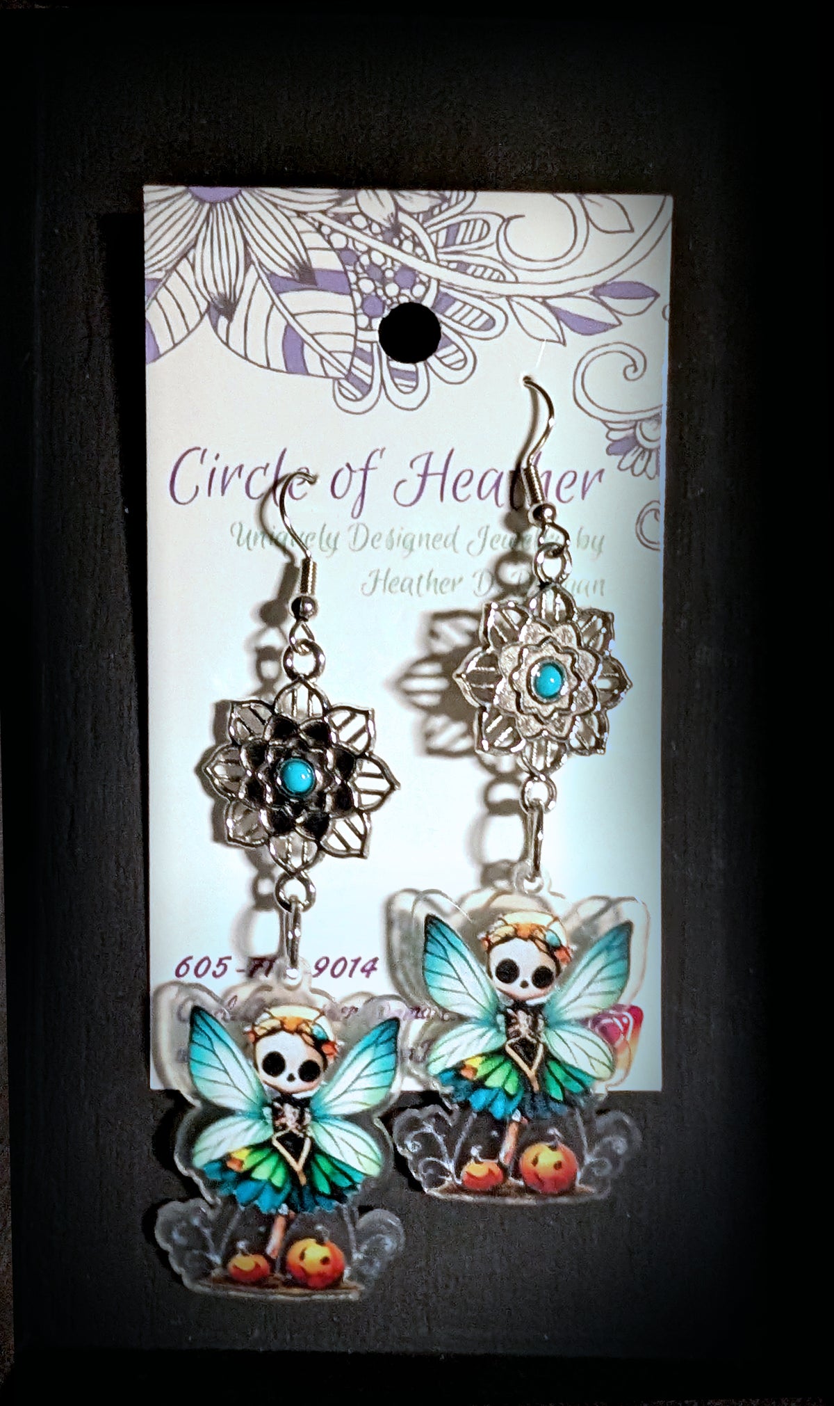 Mandala Pumpkin Skull Fairy Earrings by Circle of Heather, mandala flower tops with turquoise cabochons and printed fairy charms with teal wings and pumpkins, shown on the branded Circle of Heather card.