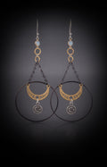 Chandelier Moonphase Earrings by Circle of Heather, full view of both earrings showing the opalescent stone top, gold rings, oxidized hoop, gold moon phase crescent and silver moon and star medallion, on a dark gradient background.