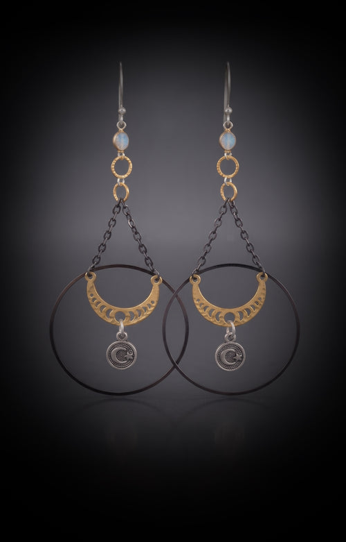 Chandelier Moonphase Earrings by Circle of Heather, full view of both earrings showing the opalescent stone top, gold rings, oxidized hoop, gold moon phase crescent and silver moon and star medallion, on a dark gradient background.
