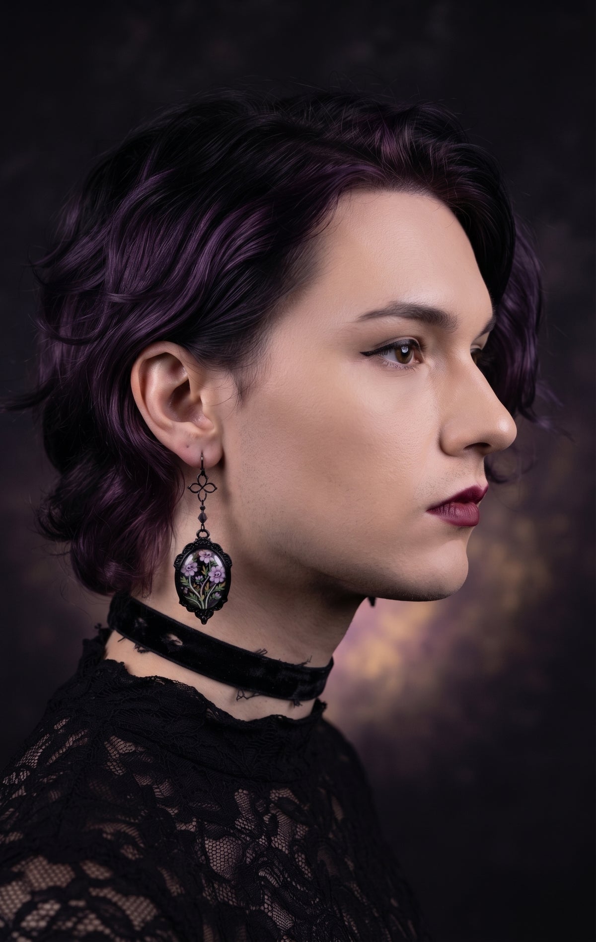 Ornamental Framed Skully Flower Earrings by Circle of Heather worn by a model with dark purple hair, black filigree frame with hand-illustrated lavender skull flower artwork