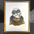 Ornamental Skull on a Platter by CamiThunderInk, an original ink and alcohol marker drawing on cream paper of a decorative skull on an ornate geometric platter, matted in a gold frame