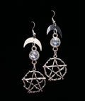 Pentacle Lunar Blue Blush Earrings by Circle of Heather, full view of both earrings showing the crescent moon, pale blue stone and the branch texture on the pentacles, on a plain black background.