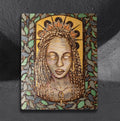 Priestess by CamiThunderInk, an original pyrography, watercolor, and gold acrylic portrait of a Black woman with long box braids, a lotus crown, and a gold ankh pendant, framed by a mosaic leaf border and a gold arch