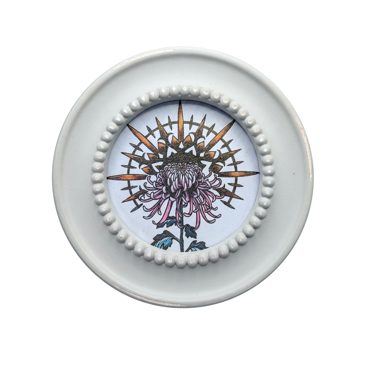 Another view of Radial Mum framed print by CamiThunderInk, a round botanical mandala of a chrysanthemum printed on shimmering pearlescent paper, in a cream round frame