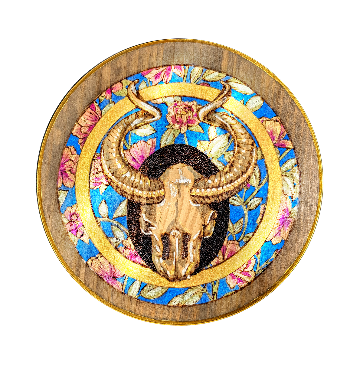 Another view of Shimmering Goat Skull by CamiThunderInk, an original pyrography and metallic watercolor painting on a 12 inch pine round of a horned goat skull inside a ring of peonies, with a gold border and stippled black halo