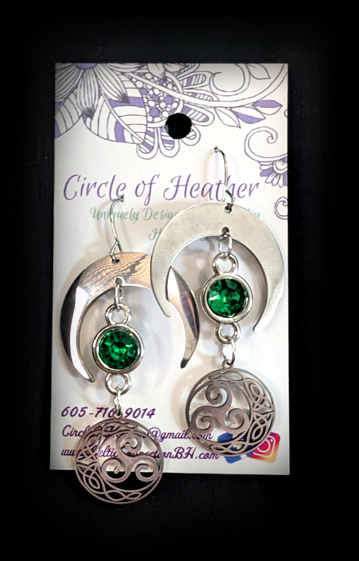Shimmer Lunar Nocturne Earrings by Circle of Heather, both earrings shown on the branded Circle of Heather card with silver crescents, green stones and triple spiral medallions.