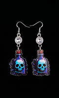 Skull Potion Earrings by Circle of Heather, full view of both earrings showing the rhinestone tops and the blue and purple potion bottle charms with skulls inside, on a plain black background.