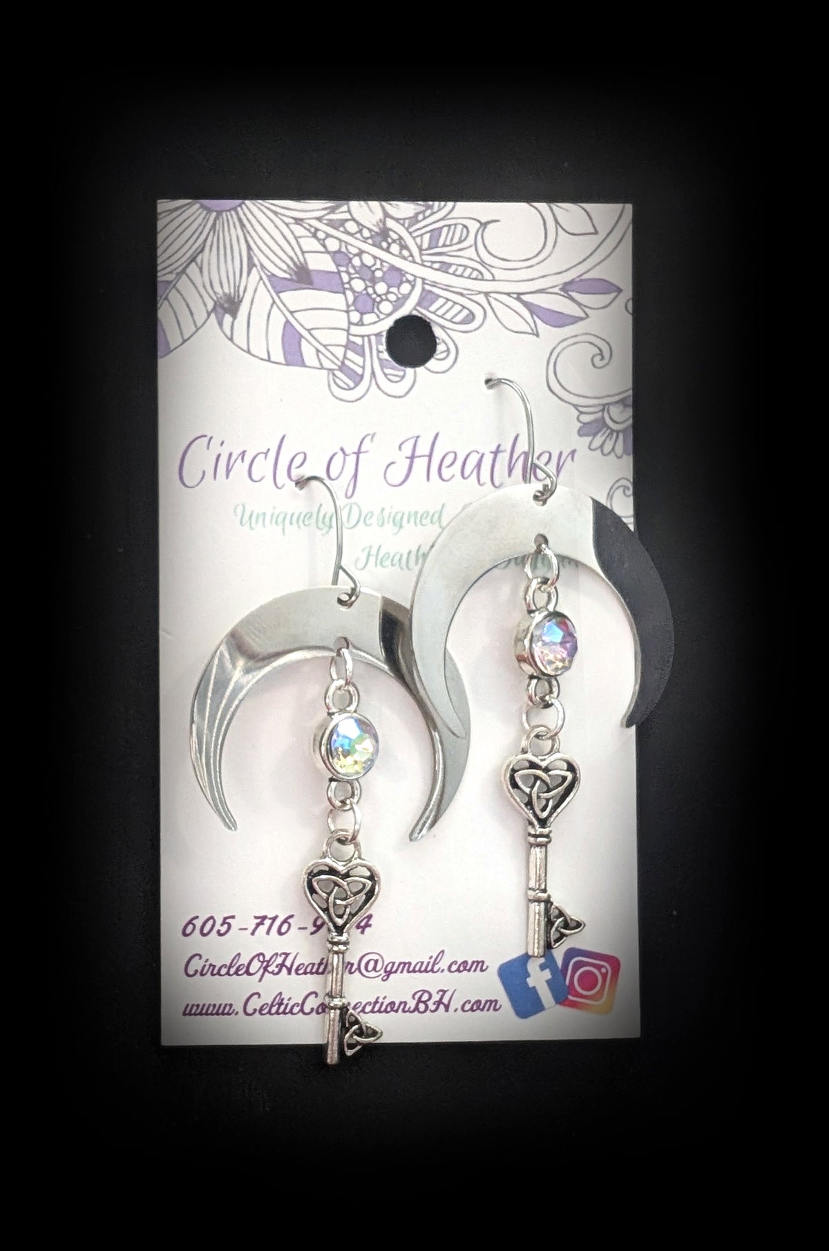 Unlock the Moon Earrings by Circle of Heather, both earrings shown on the branded Circle of Heather card with silver crescents, opalescent stones and Celtic key charms.