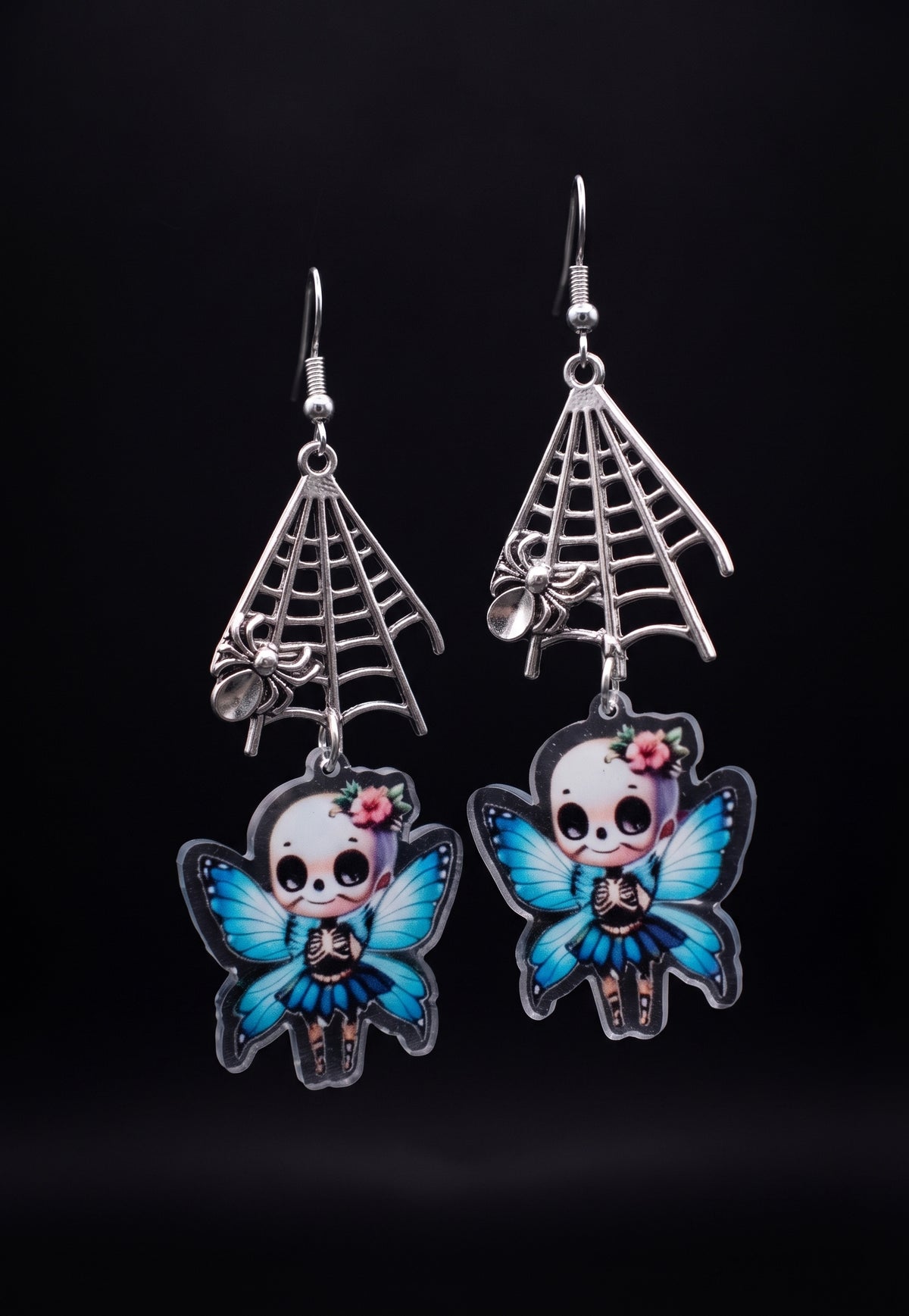 Webbed Skull Fairy Earrings by Circle of Heather, silver-tone spider web charms and printed skull fairy charms with pink flower crowns, shown on the branded Circle of Heather card.