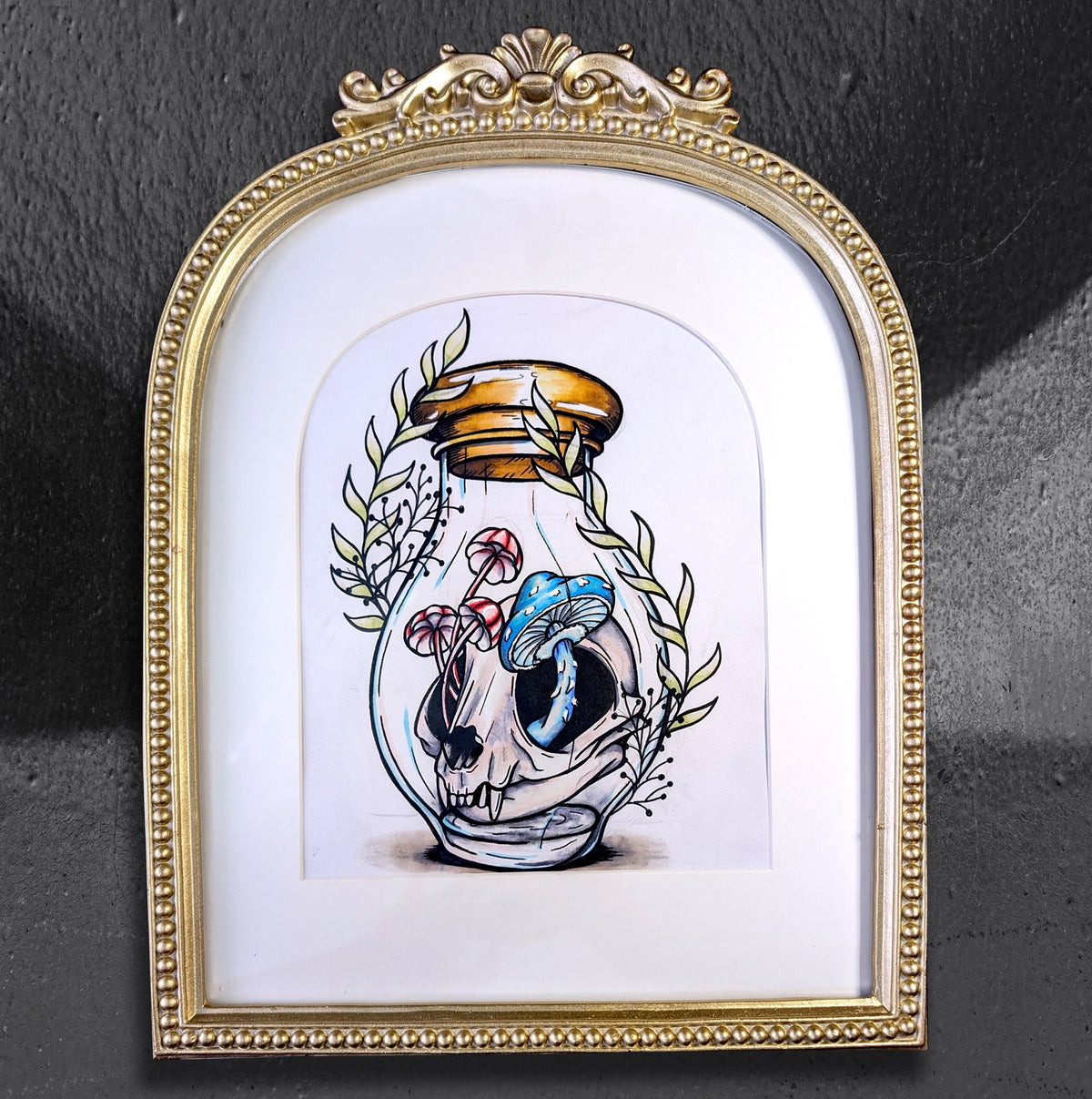 Alluring Apothecary by CamiThunderInk, an original ink and alcohol marker drawing of a raccoon skull inside a sealed apothecary jar filled with mushrooms and leaves, matted in an ornate gold arched frame