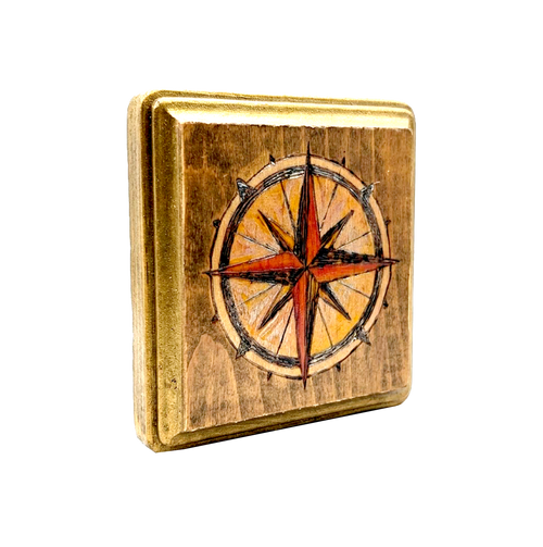 Another view of Compass flash block by CamiThunderInk, a small reclaimed pine block with a burned and painted compass rose in amber and red, with gold edging