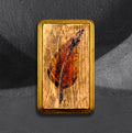Feather flash block by CamiThunderInk, a small reclaimed pine block with a burned and painted feather in auburn tones, with gold edging