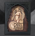 Midnight Devil by CamiThunderInk, an original pyrography and rosewood stain portrait of a devil woman on a solid wood slab, in a custom black acrylic laser cut frame