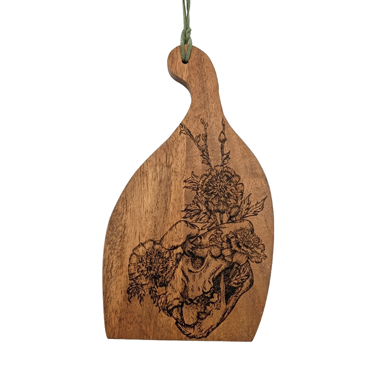 Another view of Mycelium Catworks cutting board by CamiThunderInk, an original pyrography piece on an acacia cutting board showing a cat skull covered in mushrooms and flowers, with a green hanging cord