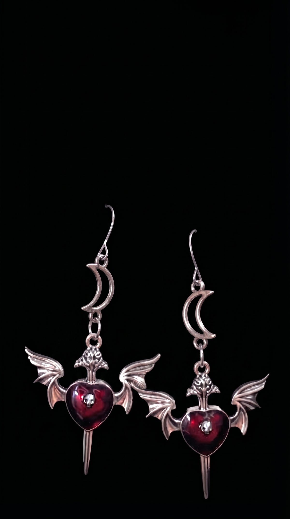 Love Soars Earrings by Circle of Heather, silver-tone dangle earrings with a crescent moon, winged heart, and dagger charm in red enamel with a skull bead accent