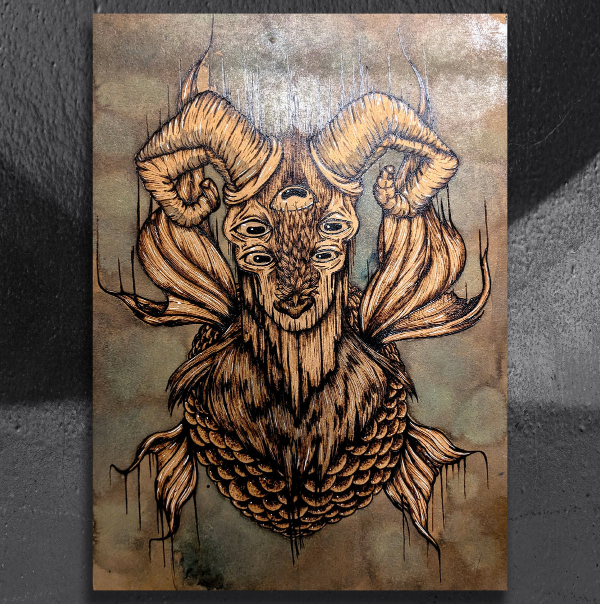 Seagoat Spectre by CamiThunderInk, an original pyrography and watercolor painting on wood of a ghostly Capricorn sea goat with many eyes, sweeping horns, and a scaled torso, emerging from a murky stained background