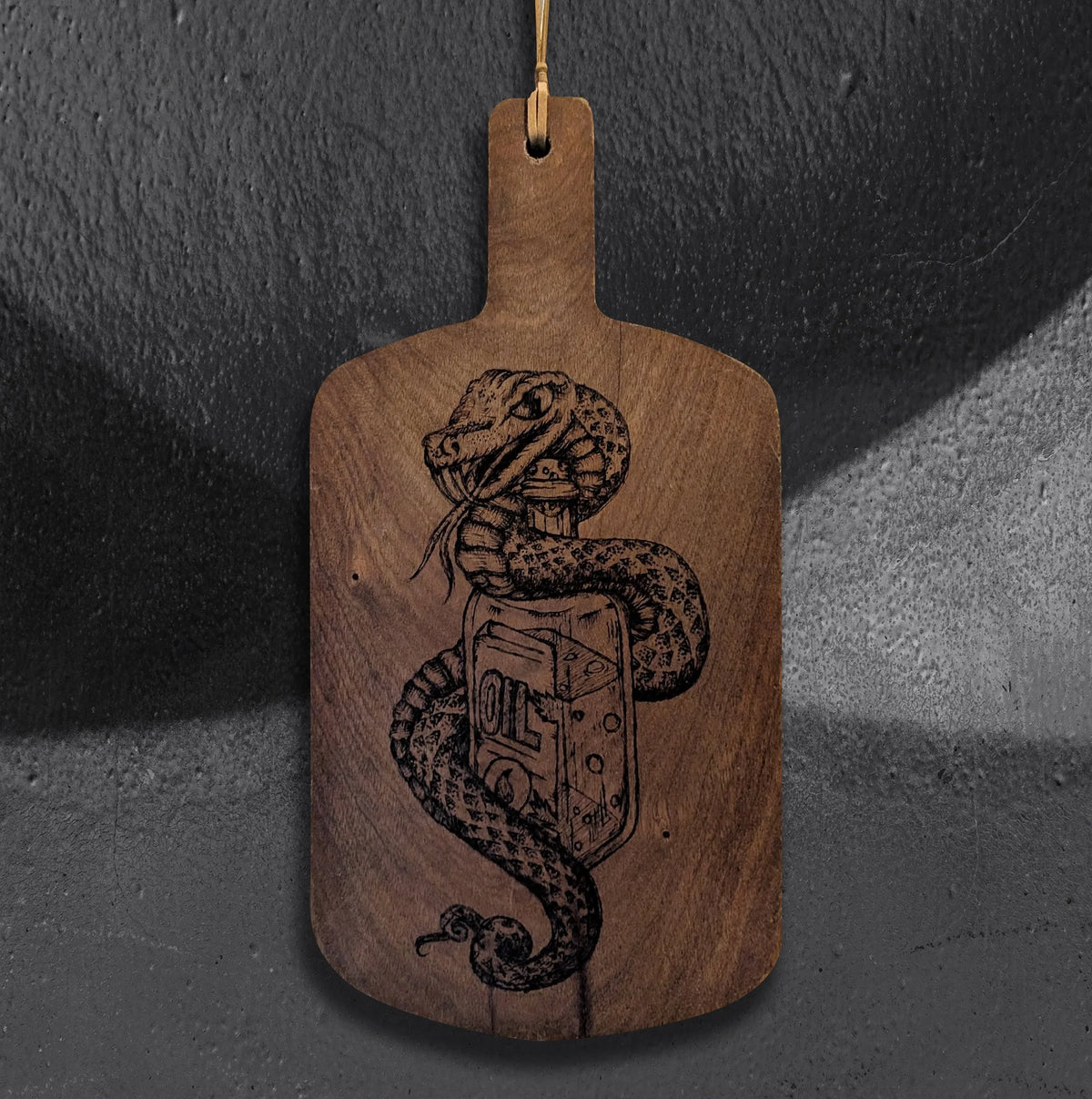 Snake Oil cutting board by CamiThunderInk, an original pyrography piece on a recycled wood cutting board showing a snake wrapped around an apothecary bottle