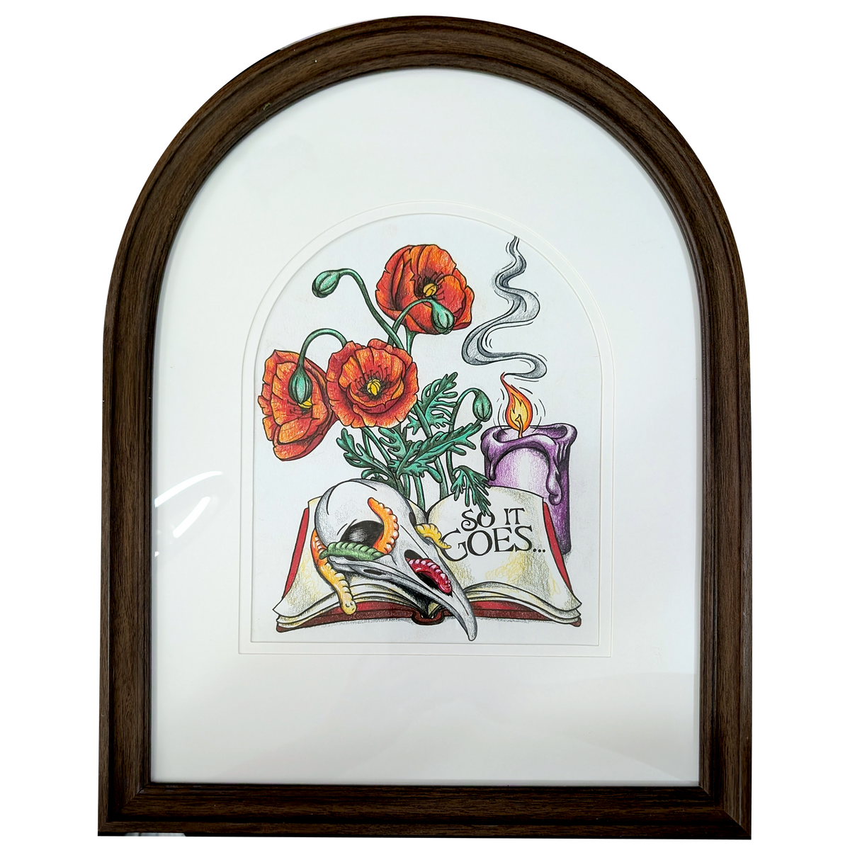 Another view of So It Goes by CamiThunderInk, an original colored pencil drawing of a raven skull, a candle, and poppies on an open book with scattered gummy worms, in an arched frame