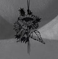Sunflower wall hanger by CamiThunderInk, a matte black 3D printed sunflower with layered petals, smaller blooms, and long veined leaves on a thin stem