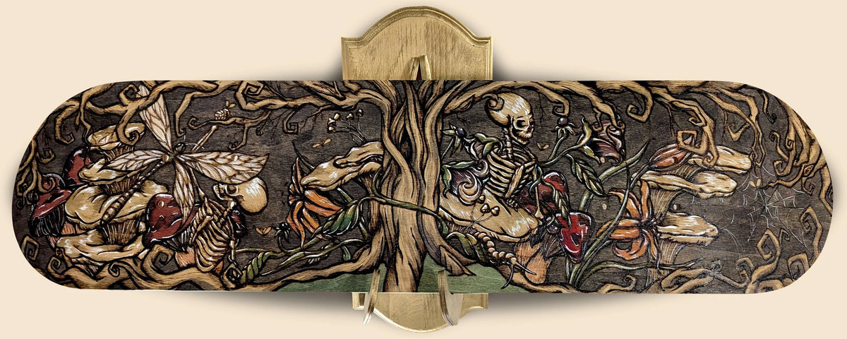 Tree of the Afterlife by CamiThunderInk, an original pyrography and watercolor painting on the underside of a maple skateboard deck showing a skeletal figure among mushrooms, lilies, and spiders