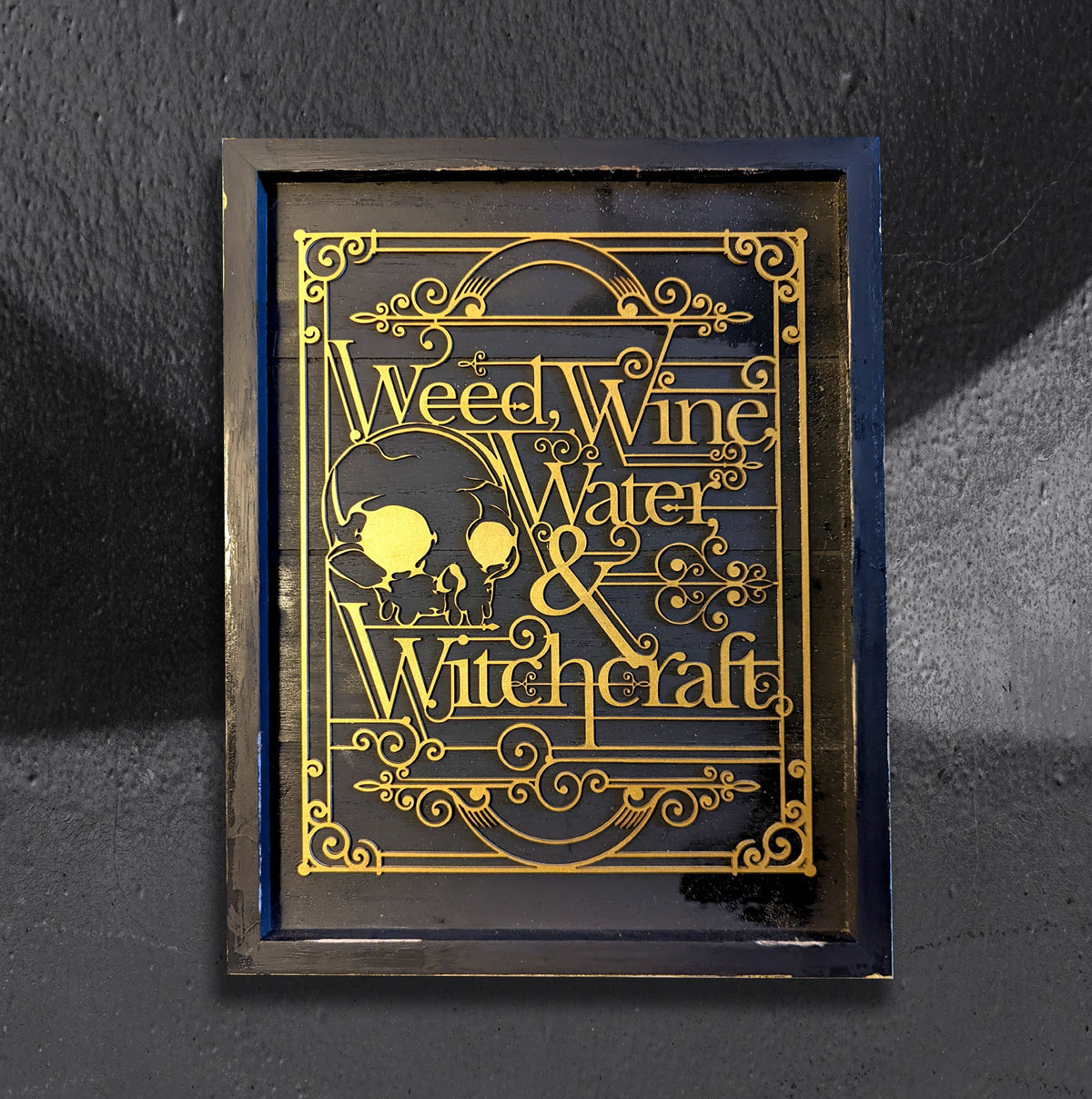 Weed, Wine, Water and Witchcraft by CamiThunderInk, gold laser cut Art Deco lettering with two witch silhouettes and scrollwork borders on a black painted wood frame